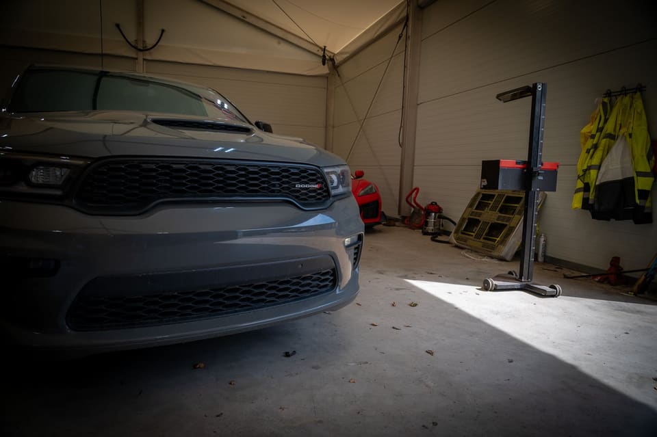 Front view of a grey Dodge Durango parked inside a workshop bay.
